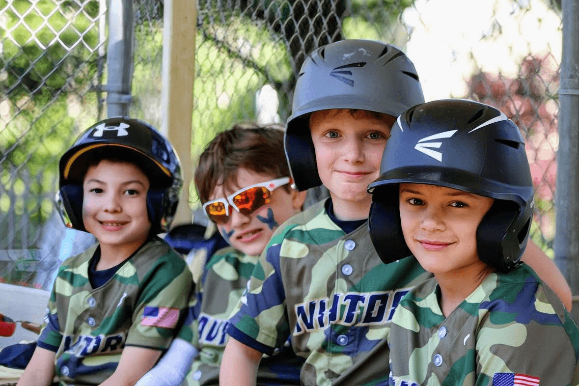 Young CT Aviators players smiling together in the dugout