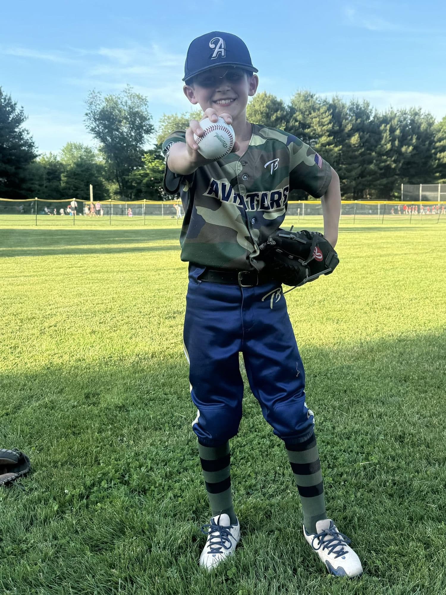A young CT Aviators player proudly holding a baseball